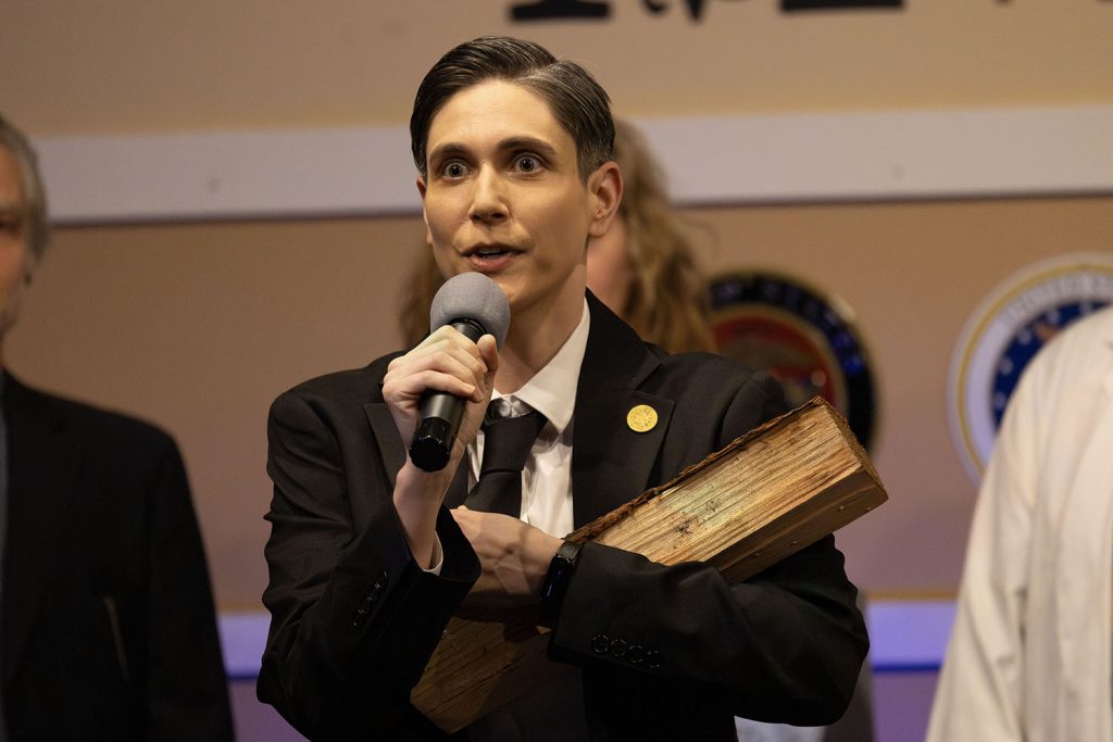 Improv actor holding a log on stage