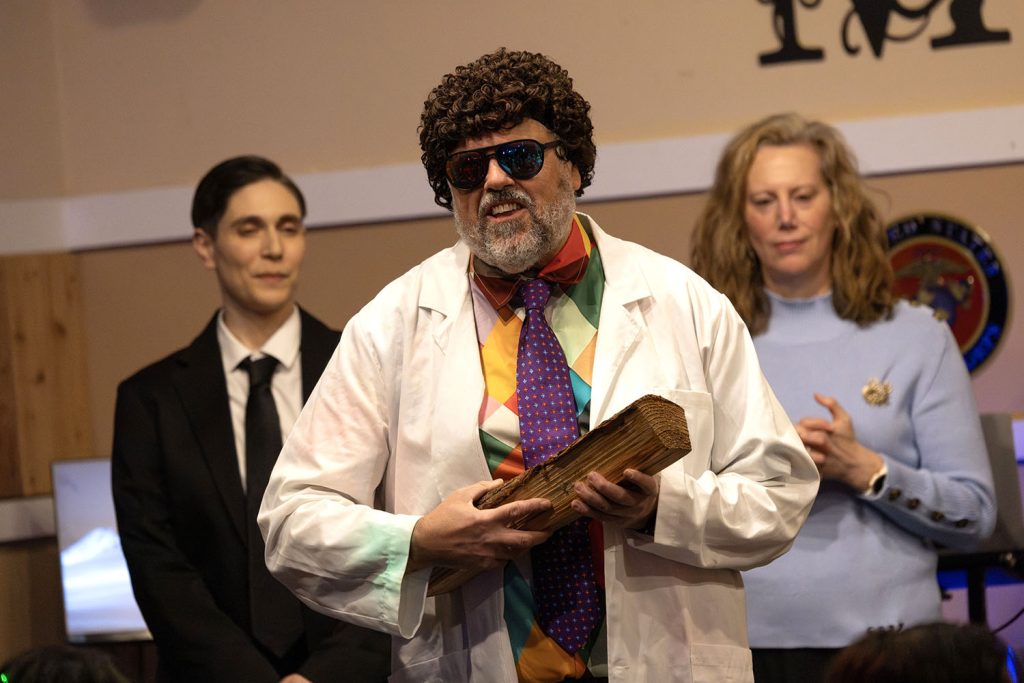 Improv actor holding a log on stage