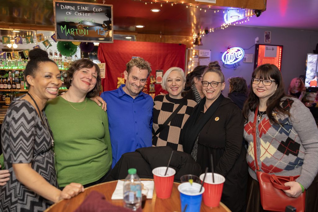 Line of people standing in a bar
