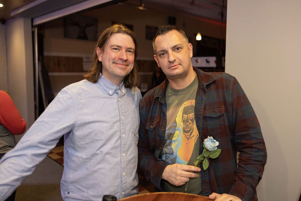 Two people standing in a bar