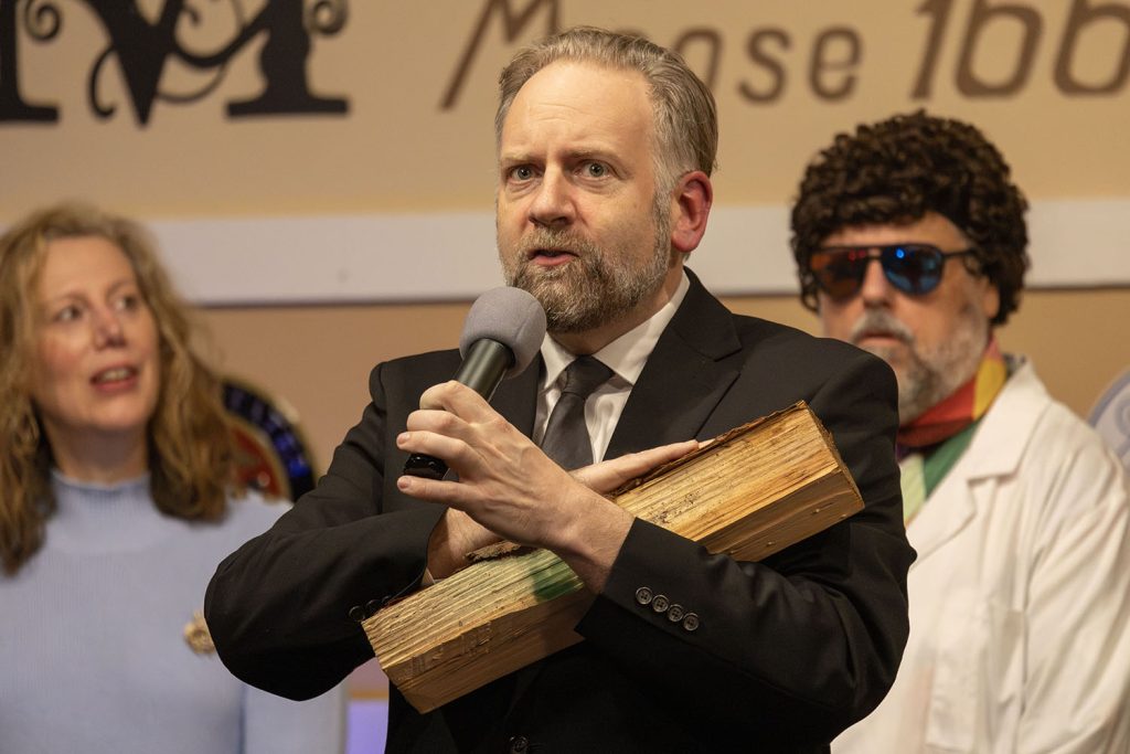 Improv actor holding a log on stage