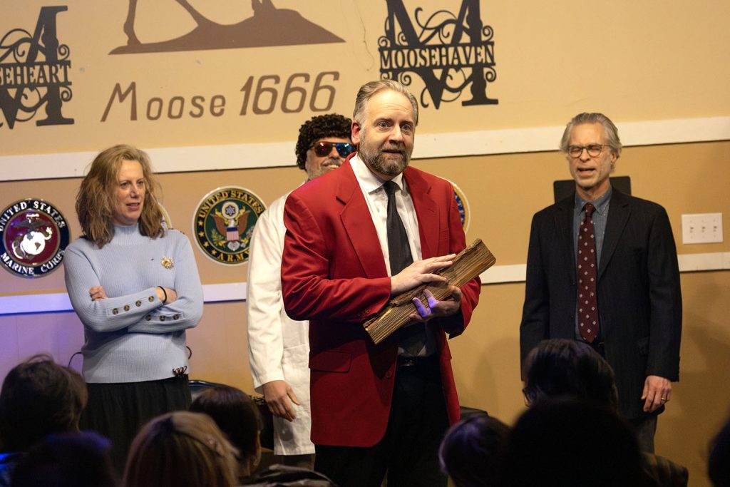 Improv actor holding a log on stage