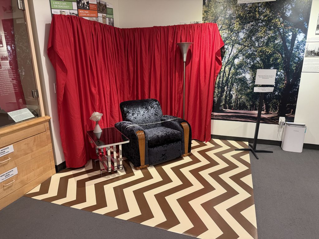 Jason Mattson's Red Room Chair in a display with chevron floor and red curtains
