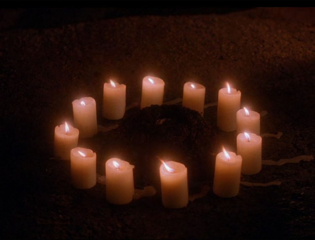 Circle of candles surrounding a pile of dirt