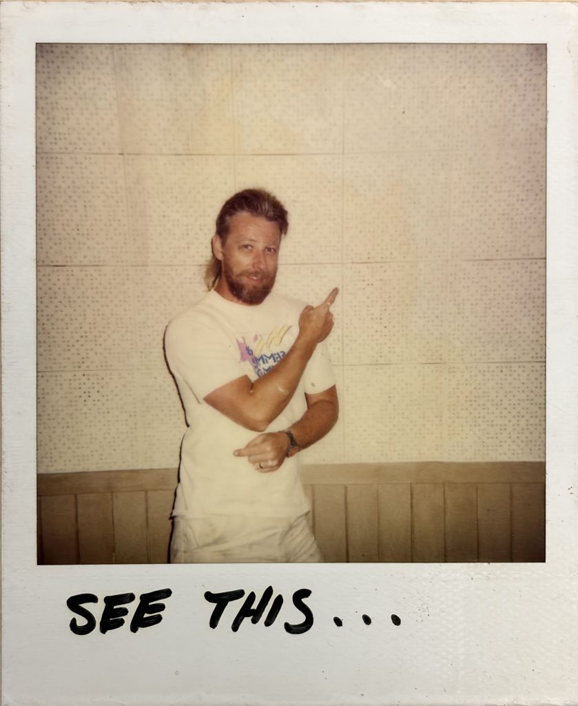 Polaroid photo of Dave Robinson standing in front of acoustic tile
