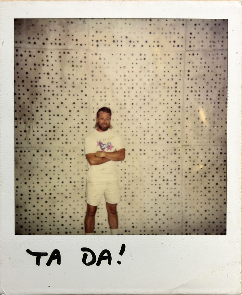 Polaroid photo of Dave Robinson standing in front of acoustic tile