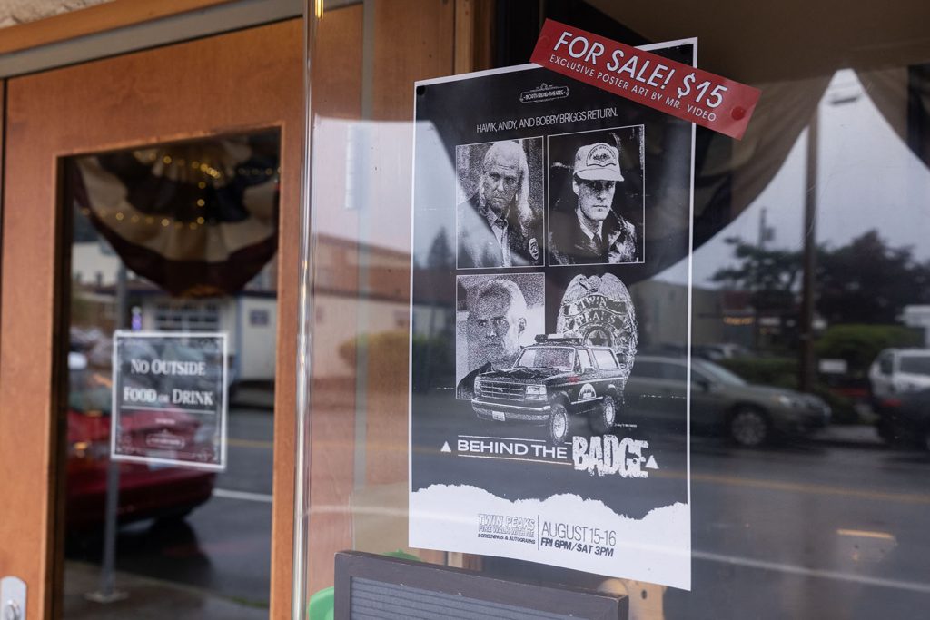 Behind the Badge poster hanging on a window