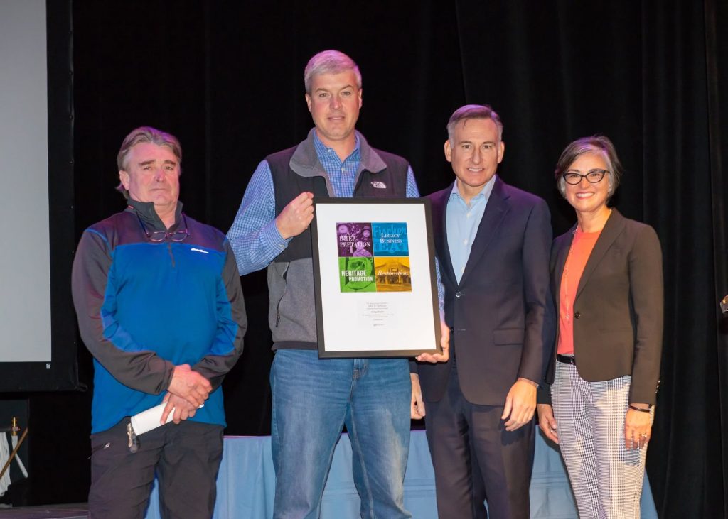 Craig Glazier receiving his award for restoration of the Sunset Garage facade from King County Executive Dow Constantine.