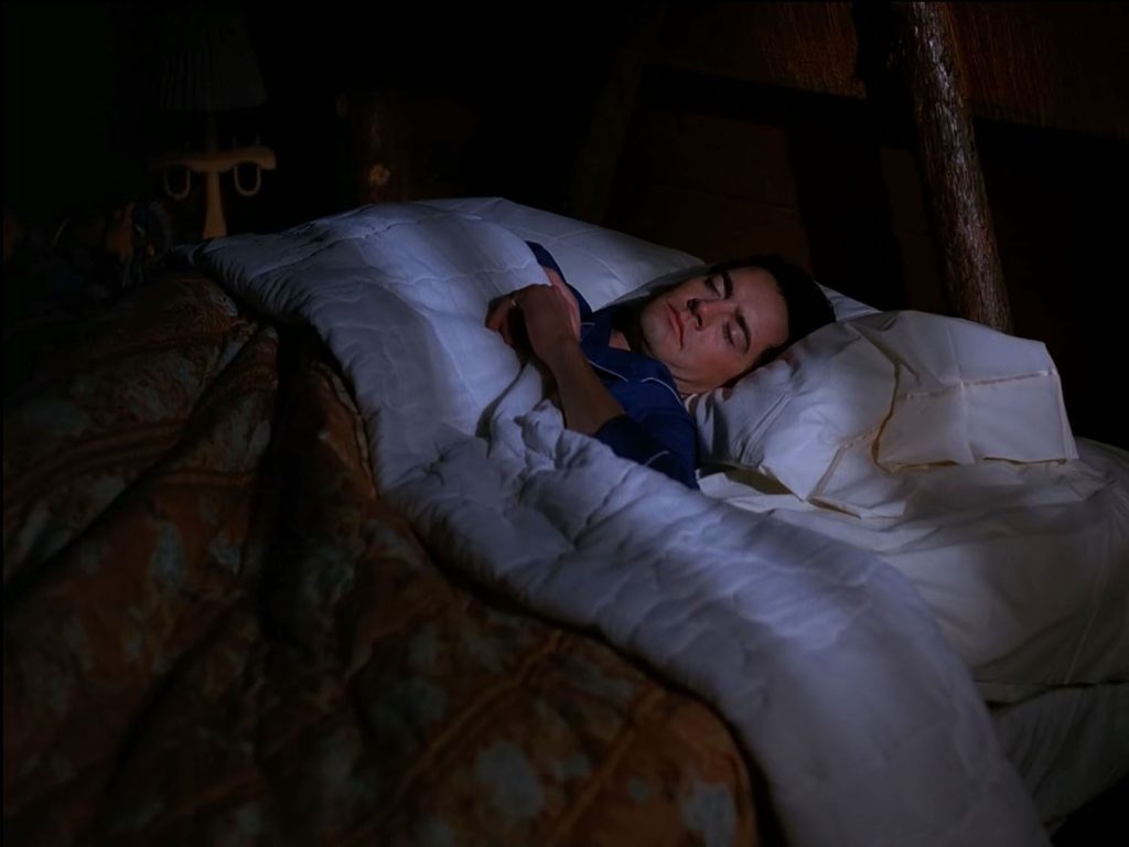 Special Agent Dale Cooper sleeping in his bed.