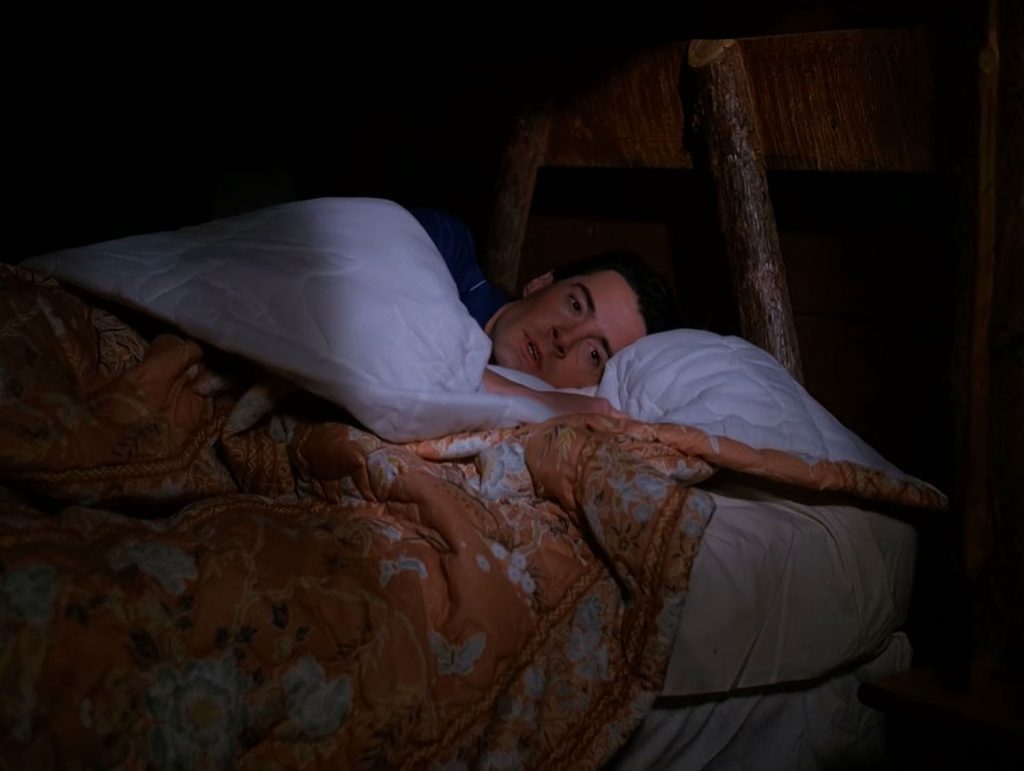Special Agent Dale Cooper waking up in his bed.