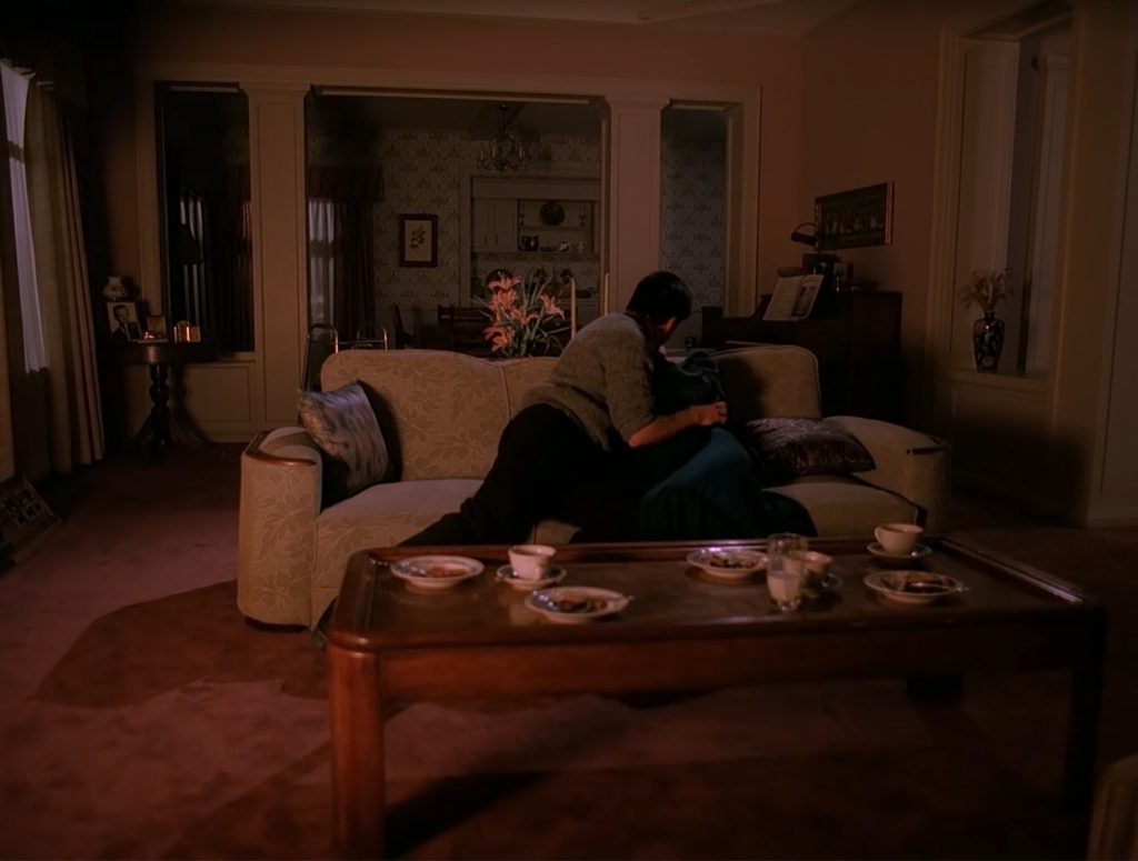 Donna and James sitting on the couch and kissing