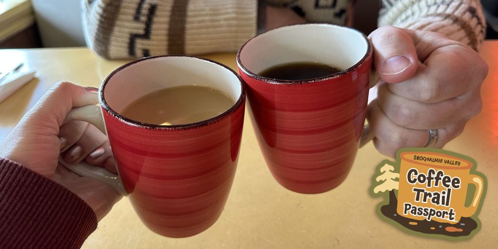 Two people holding cups of coffee at Twede's Cafe