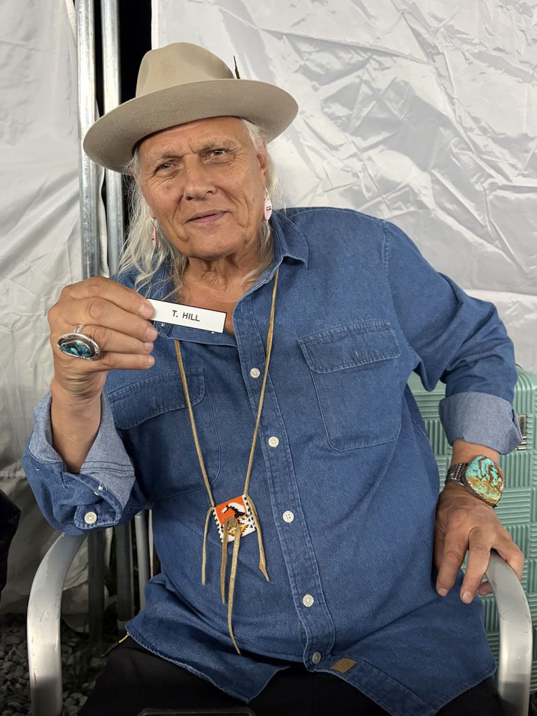 Michael Horse holding T. Hill name tag