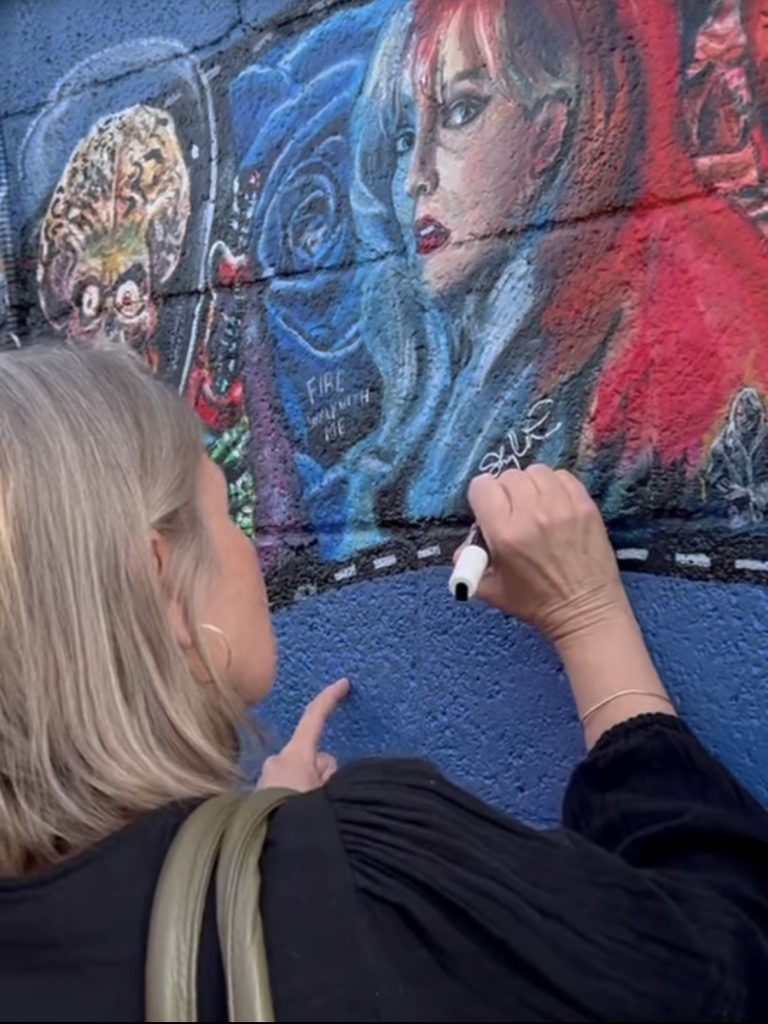Sheryl Lee signing the mural