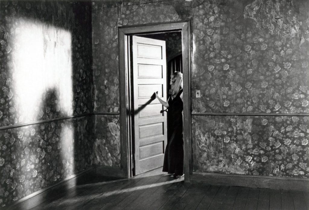 Black and white photo of Laura Palmer standing at the doorway from Twin Peaks: Fire Walk With Me