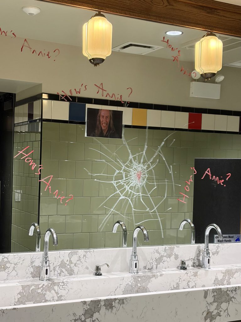 Inside of a bathroom with sink and fake cracked mirror