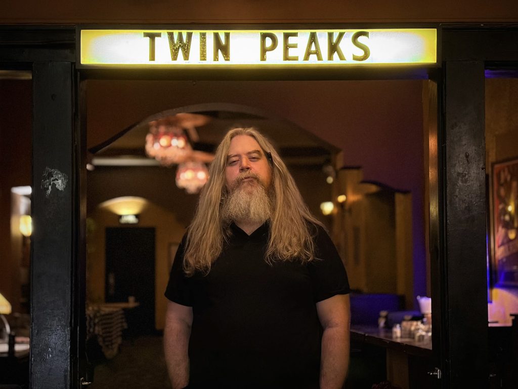 Daniel Knox standing under a Twin Peaks marquee at the Music Box Theatre in Chicago, Illinois