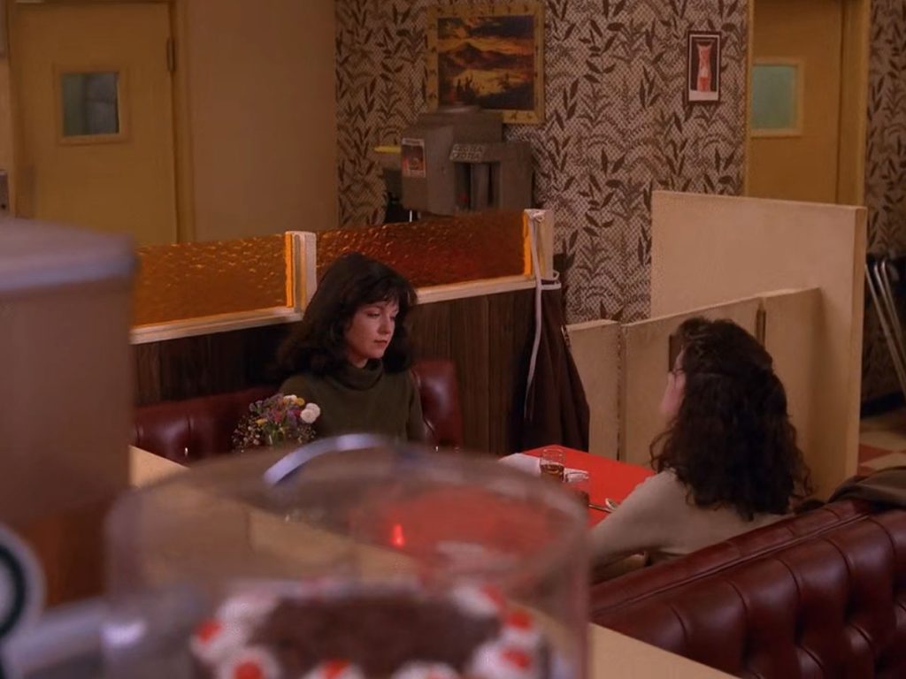 Maddy Ferguson and Donna Hayward talking while seated in a booth at the Double R Diner