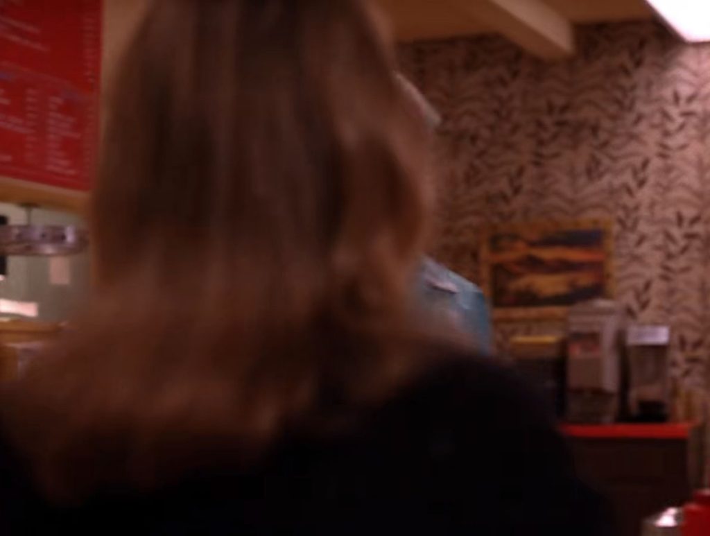 Back of Annie Blackburn sitting at the counter